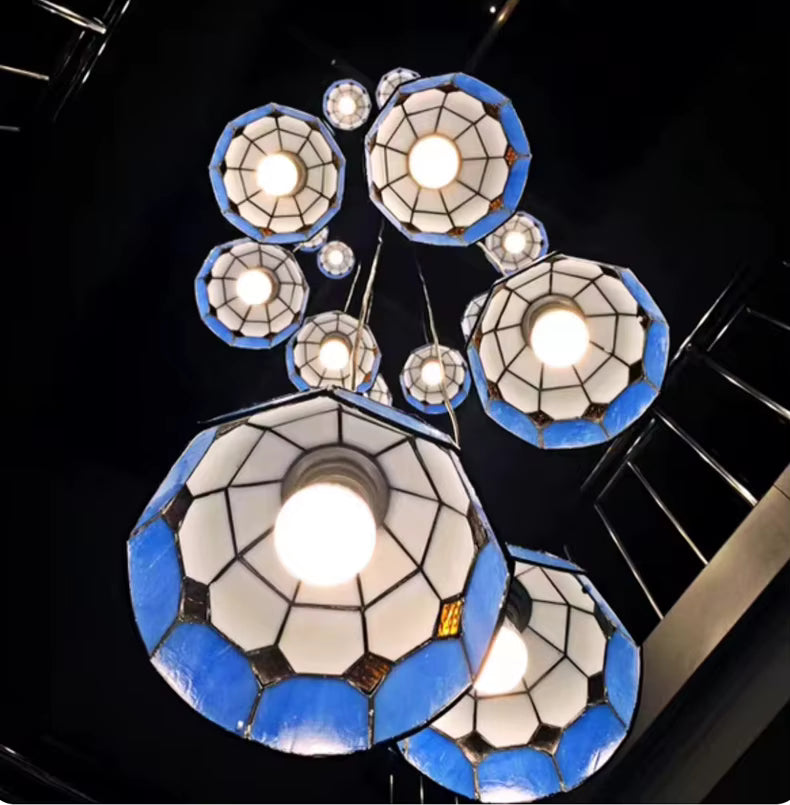 Suspension cascade en vitrail bleu style Tiffany illuminée dans un escalier à grande hauteur