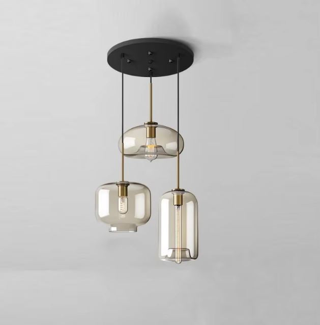 Suspension cascade vintage avec trois abat-jours en verre fumé pour un éclairage moderne et raffiné.