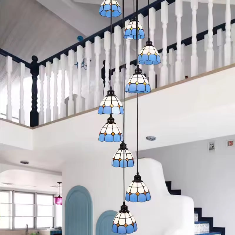 Suspension cascade style Tiffany à abat-jour en vitrail bleu installée dans une grande cage d’escalier