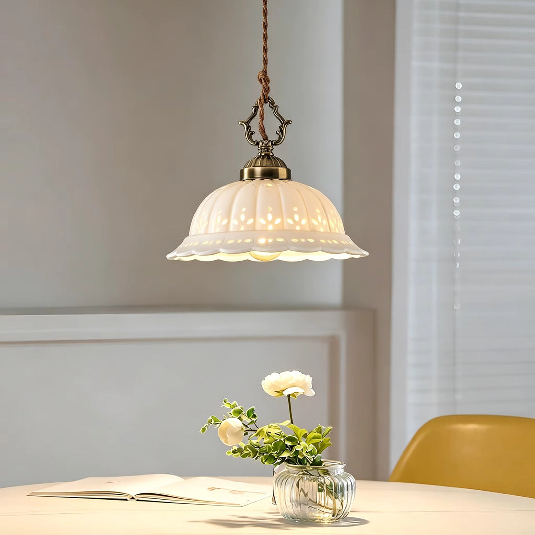 Au-dessus d’une table, suspension en céramique blanche ajourée et laiton vieilli au charme rétro élégant