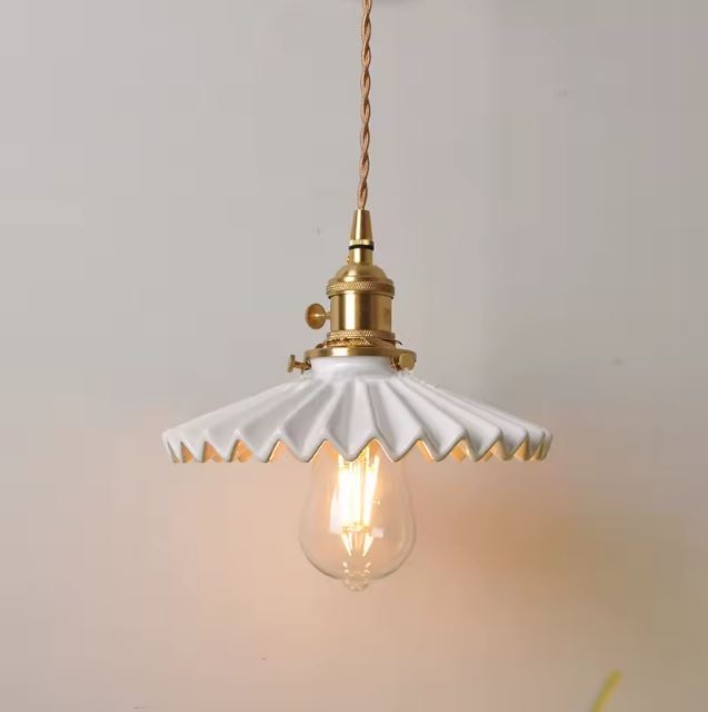 Suspension en céramique blanche nervurée à collerette plissée, idéale pour un intérieur vintage chic ou un décor scandinave lumineux.