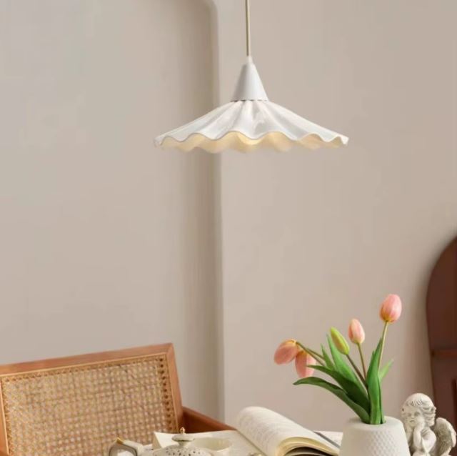 Suspension en céramique blanche ondulée effet jupe plissée, style bohème chic dans un intérieur chaleureux.