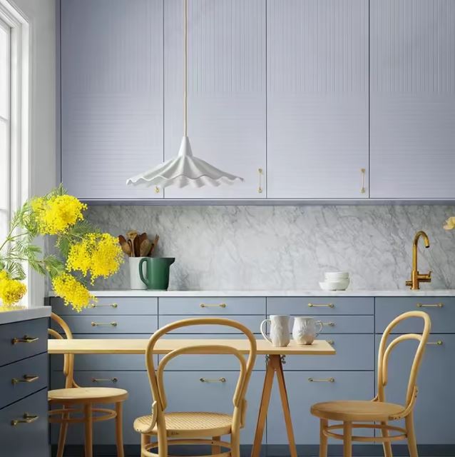 Suspension en céramique blanche ondulée effet jupe plissée, ambiance bord de mer chic dans une cuisine lumineuse.