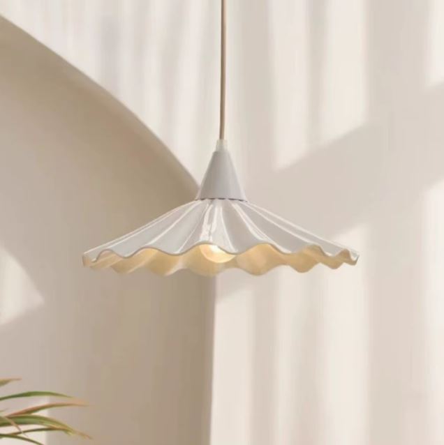 Suspension en céramique blanche ondulée effet jupe plissée, style japandi lumineux et ambiance douce.