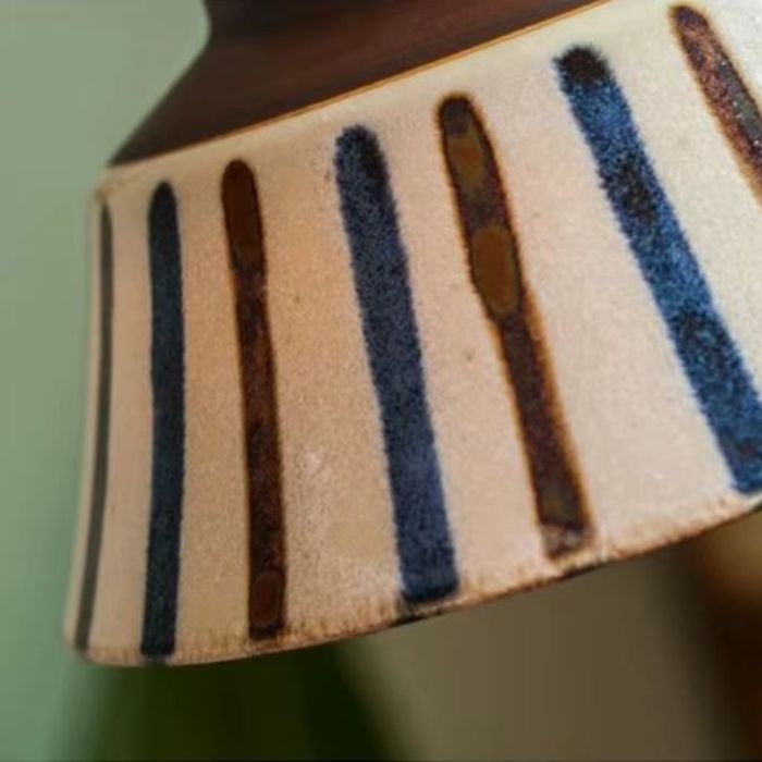 Zoom sur la suspension en céramique écrue avec bandes bleues et brunes, design minimaliste et élégant, parfait pour un intérieur scandinave ou vintage.