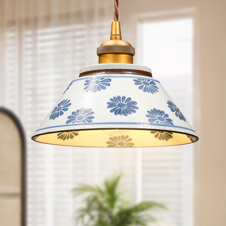 Suspension en céramique à motifs floraux bleus suspendue dans un intérieur lumineux au décor épuré.