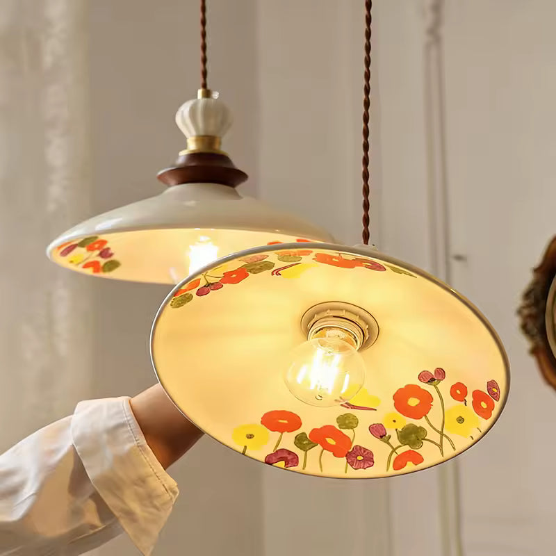 Vue sous une suspension en céramique fleurie au style champêtre rétro, diffusant une lumière chaude et douce