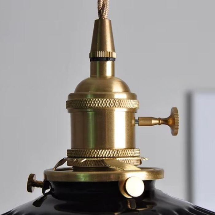 Suspension en céramique noire nervurée à collerette plissée avec douille en laiton vintage et interrupteur, idéale pour un décor industriel élégant.