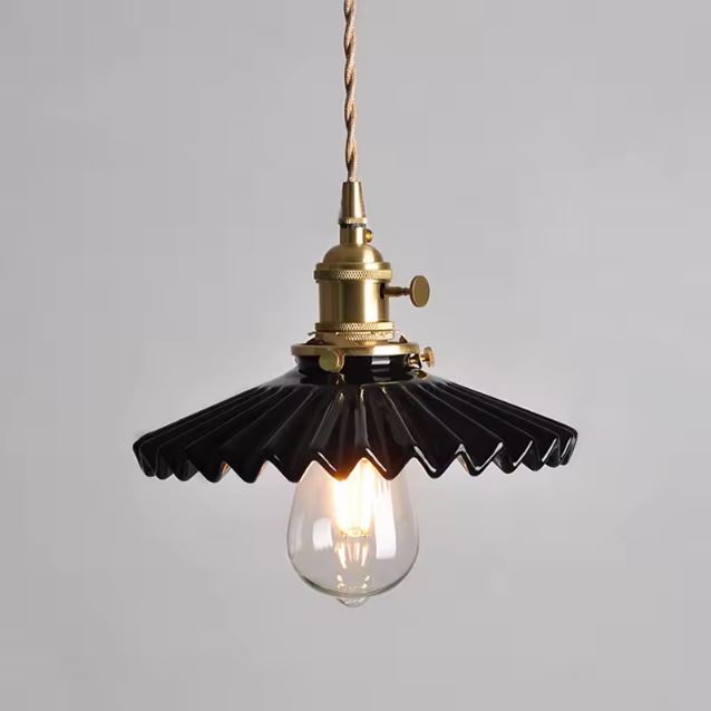 Suspension en céramique noire nervurée à collerette plissée, éclairée, parfaite pour un intérieur industriel chic, rétro moderne ou art déco revisité.