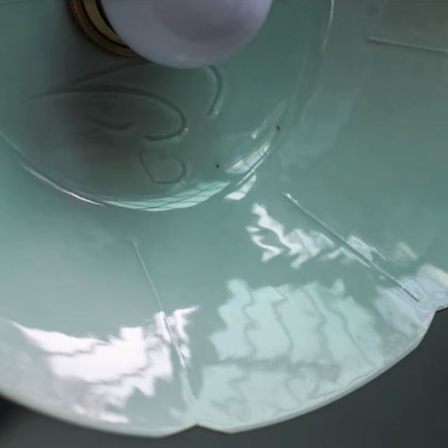 Suspension en céramique vert d’eau aux courbes ondées, détail intérieur révélant un style rétro discret mêlé à une esthétique artisanale naturelle.