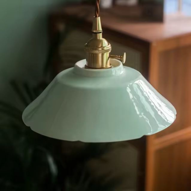 Suspension en céramique vert d’eau aux courbes ondées, au design rétro minimaliste apportant une touche douce et élégante à un intérieur naturel.