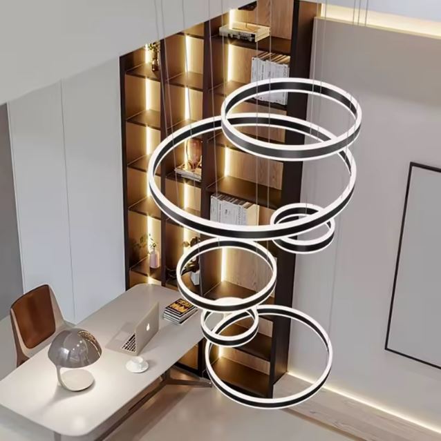 Suspension cerceau LED pour bureau moderne, apportant un éclairage sculptural au-dessus d’une bibliothèque design.
