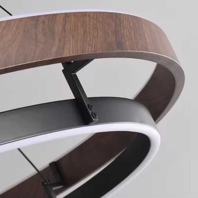 Détail d’une suspension cercle bois et métal avec finition texturée bois, soulignant la qualité des matériaux et l’assemblage soigné.