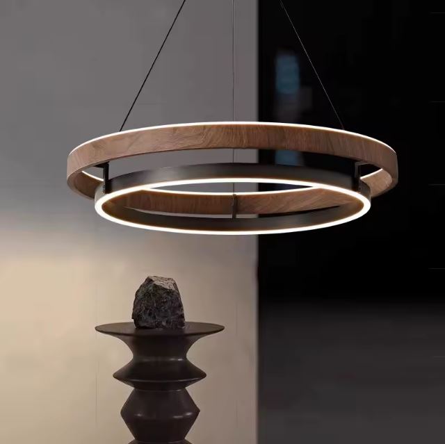 Suspension cercle bois et métal au design sculptural, parfaite pour une ambiance moderne et minérale avec éclairage doux et ciblé.