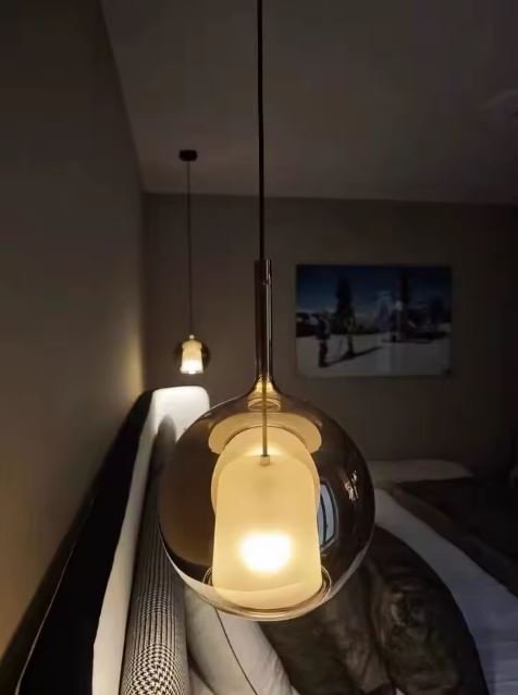 Suspension de chevet en verre fumé, globe élégant pour chambre au style contemporain et feutré.