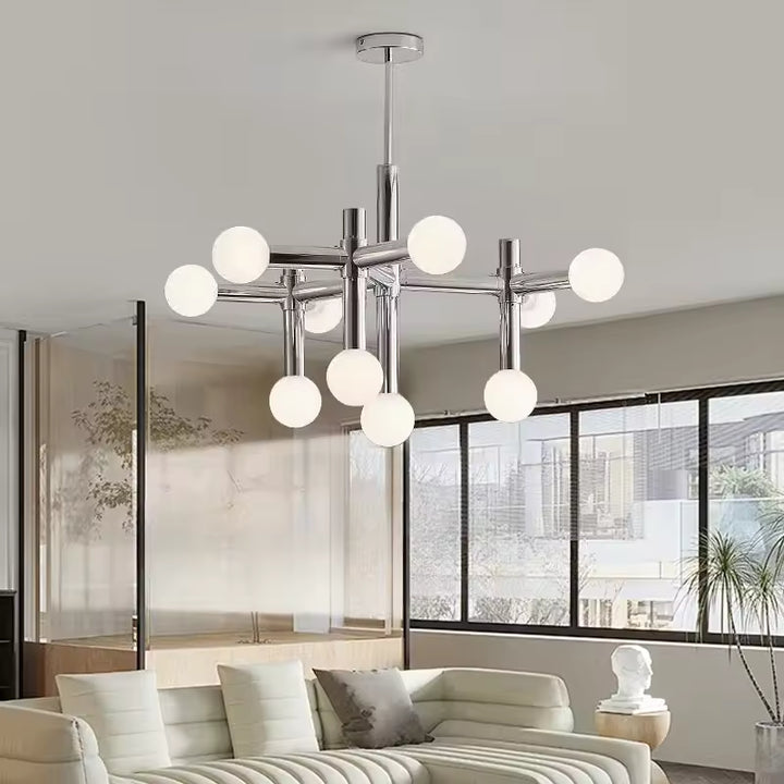 Suspension chromée à globes opalins dans un salon lumineux, avec une allure contemporaine et graphique