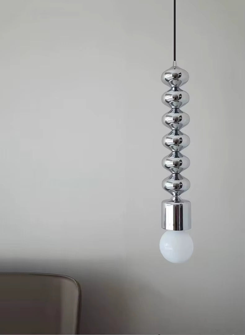 Reflets chromés et globe opalin soulignent le caractère sculptural de cette suspension au style contemporain