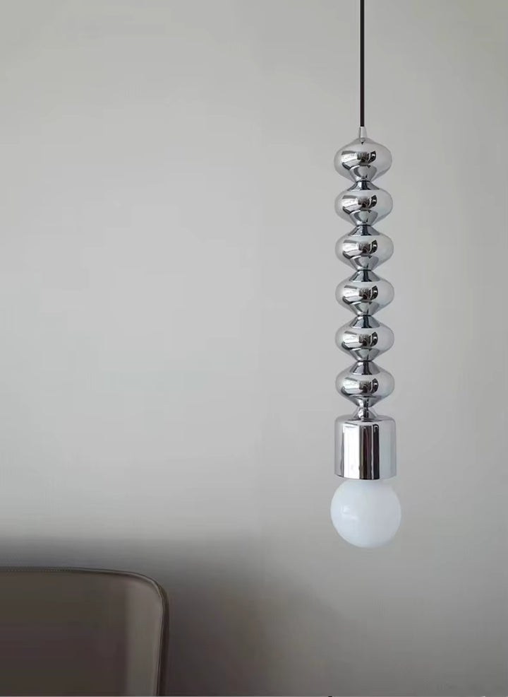 Reflets chromés et globe opalin soulignent le caractère sculptural de cette suspension au style contemporain