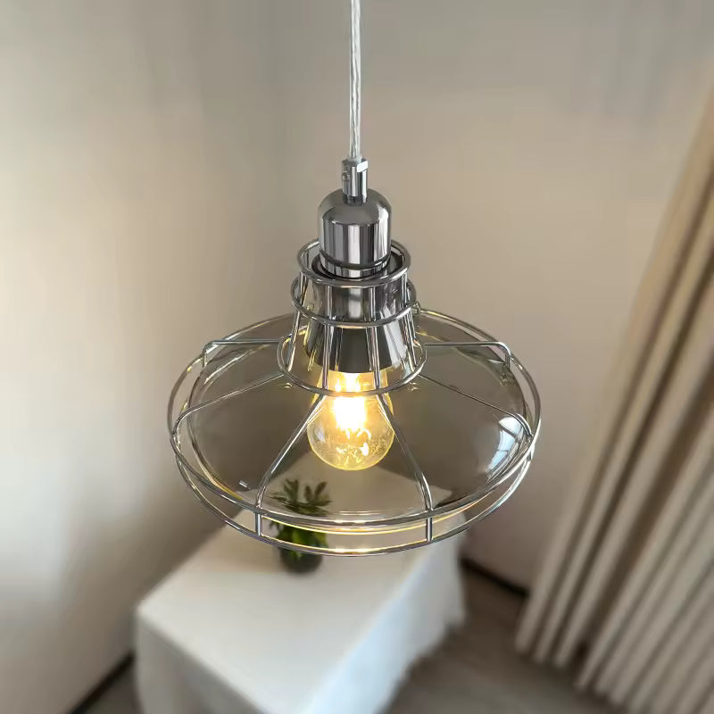 Éclairage suspendu rétro en verre transparent cerclé de métal chromé, avec ampoule apparente et allure industrielle vintage