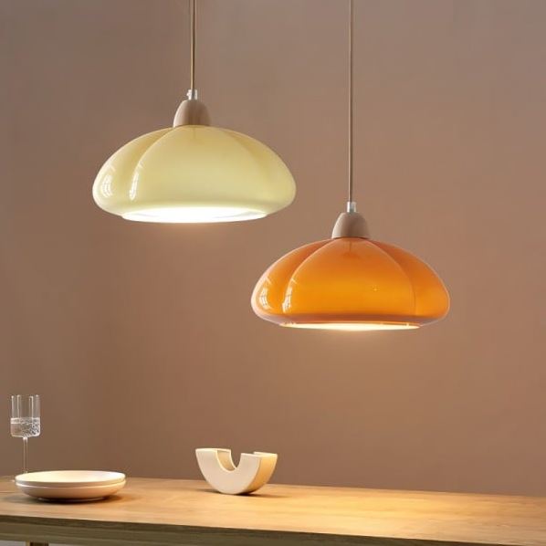 Suspensions bicolore en forme de citrouille éclairant élégamment une salle à manger avec un style doux et moderne.