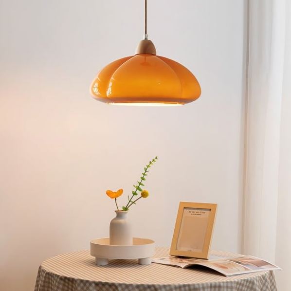 Suspension citrouille orange au design élégant, parfaite pour illuminer un salon ou une salle à manger moderne.