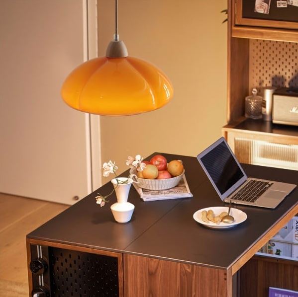 Suspension citrouille orange éclatante illuminant une cuisine moderne avec élégance et style chaleureux.