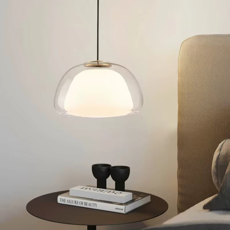 Suspension en verre transparent avec diffuseur opalin, mise en scène dans une chambre au style chic et contemporain