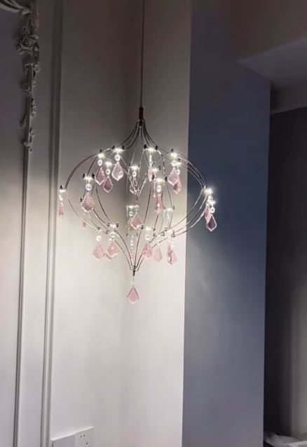 Suspension cœur illuminée en acier inoxydable avec pampilles en cristal rose au style féérique et aérien.