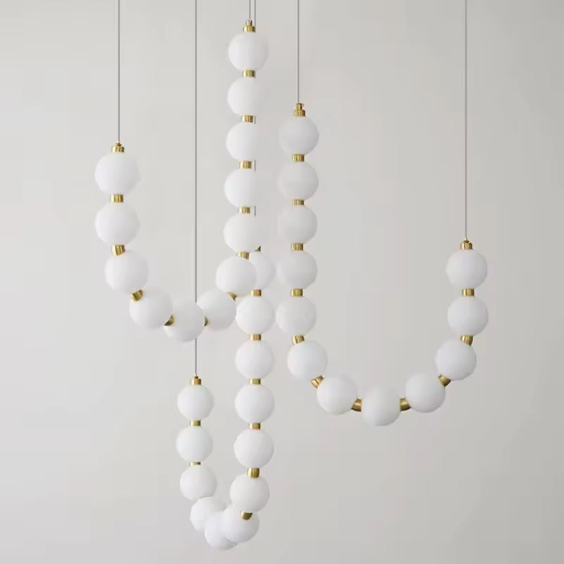 Composition sculpturale de globes lumineux blancs et dorés formant une suspension design au style organique