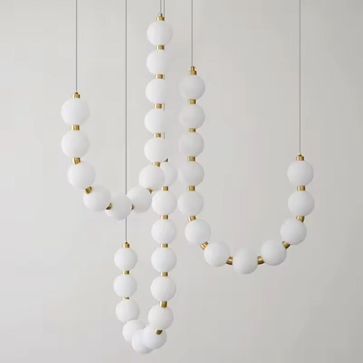 Composition sculpturale de globes lumineux blancs et dorés formant une suspension design au style organique