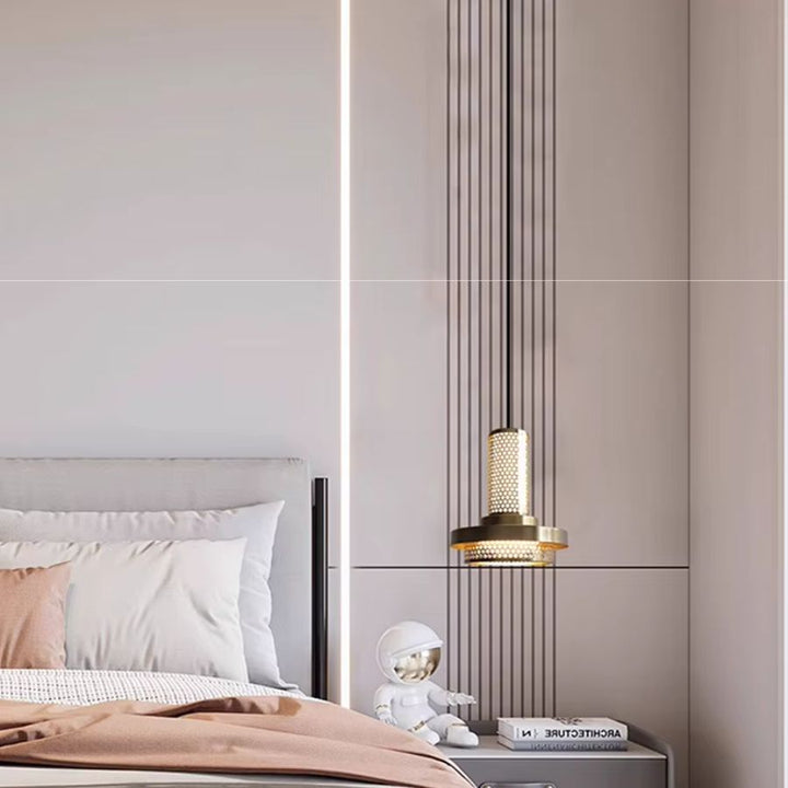 Dans une chambre contemporaine, une suspension dorée à colonne ajourée et disque éclaire élégamment le chevet