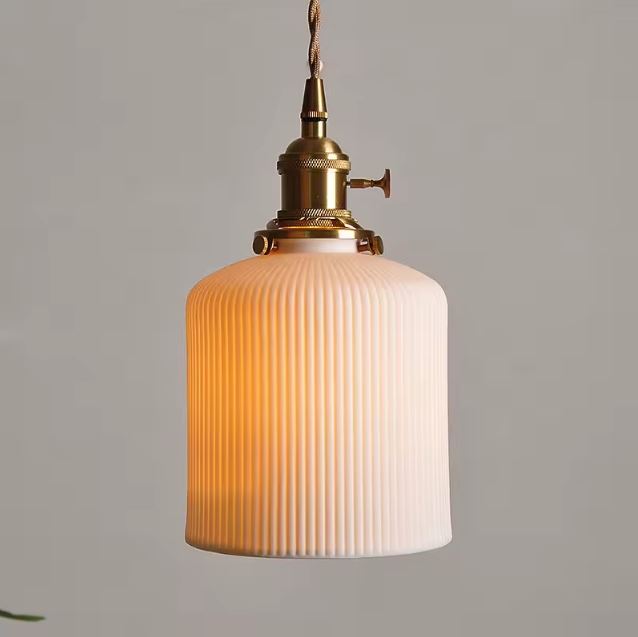 Suspension Colonne Cannelée en Céramique Blanche diffusant une lumière chaude, idéale pour une ambiance art déco, minimaliste ou contemporaine.