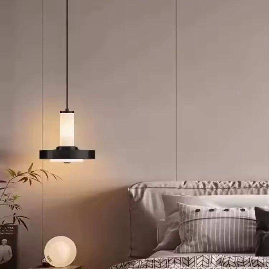 Suspendue près du lit, cette lampe à colonne et disque en métal noir crée une ambiance moderne et chaleureuse