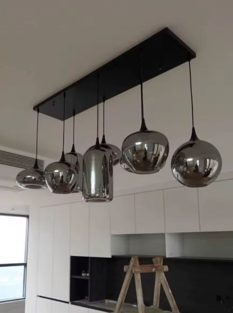 Suspension en verres fumés aux formes sphériques et cylindriques, inspirée du design contemporain haut de gamme.