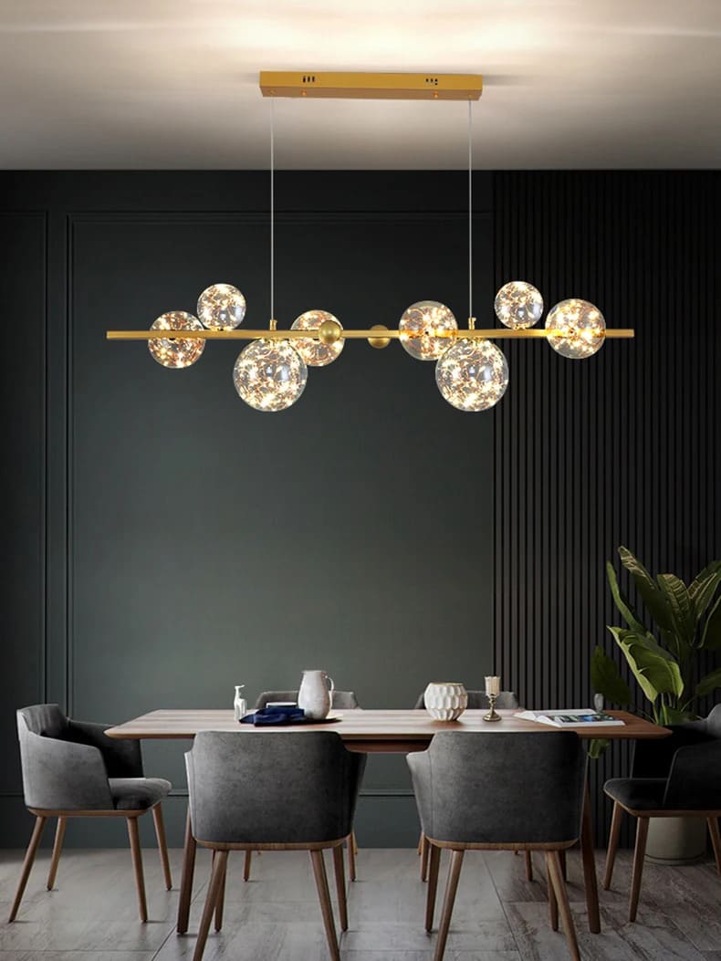 Suspension constellation dorée illuminant une grande table de salle à manger chaleureuse