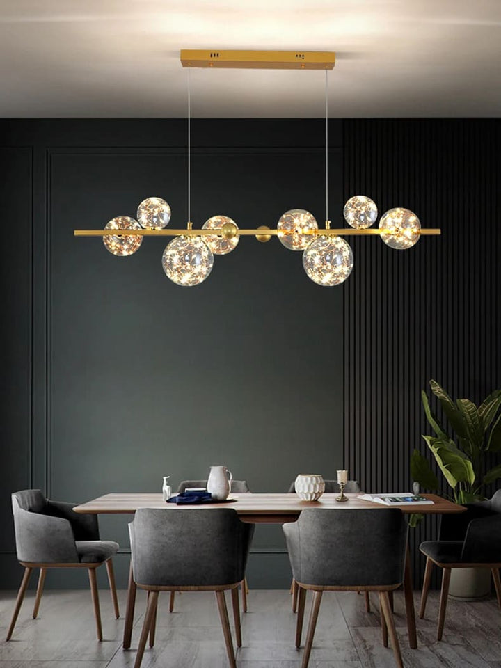 Suspension constellation dorée illuminant une grande table de salle à manger chaleureuse