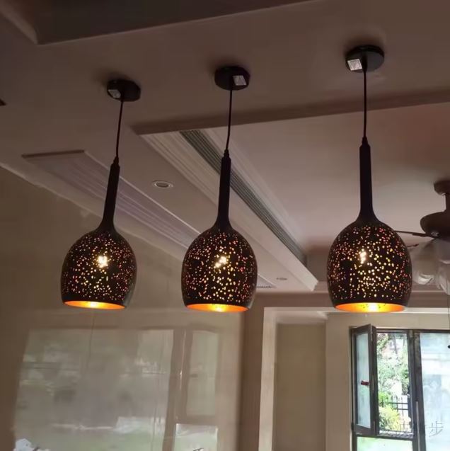 Trio de suspensions en métal noir perforé en forme de goutte, projetant une lumière étoilée au style oriental moderne.