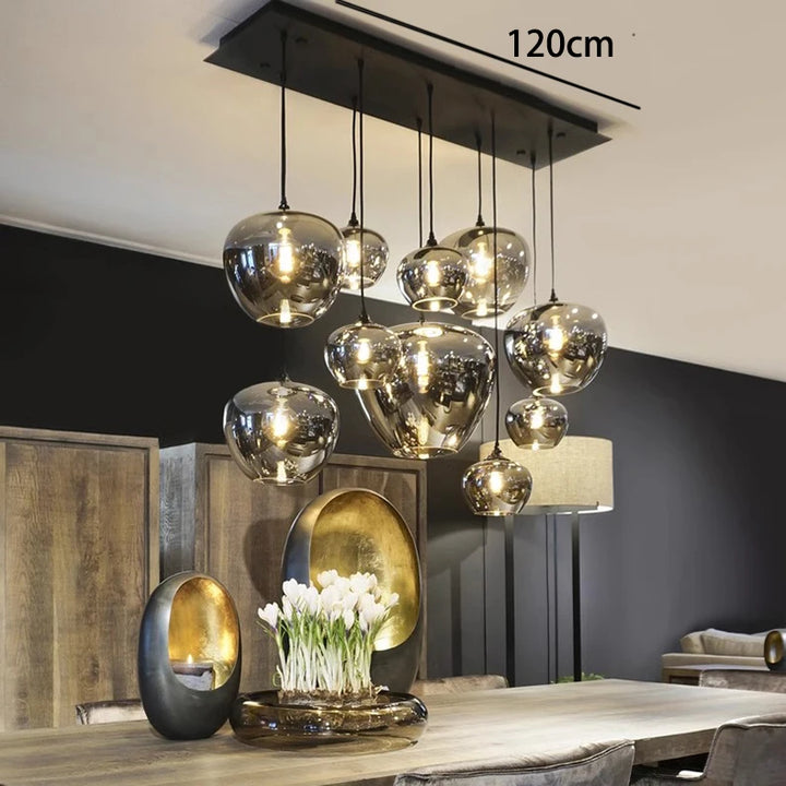 Grande suspension contemporaine en verre fumé installée au-dessus d'un îlot de cuisine moderne.