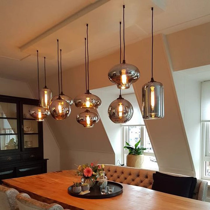 Grande suspension contemporaine en verre fumé suspendue au-dessus d'une table de salle à manger.