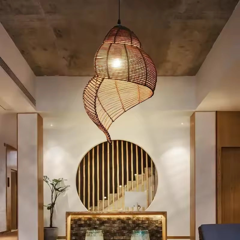 Au centre d’une entrée contemporaine, cette suspension en rotin tressé affiche une silhouette organique et sculpturale