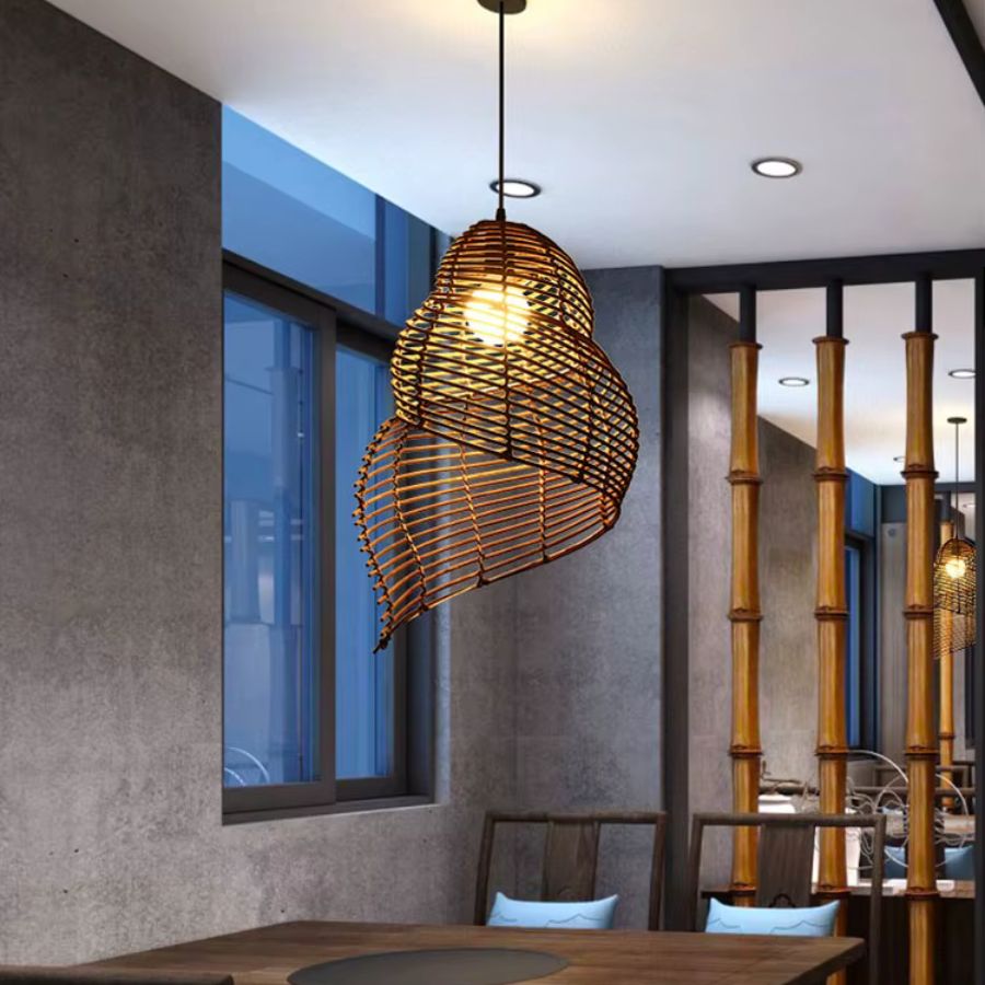 Au-dessus d’une table en bois, cette suspension coquillage en rotin tressé affirme un style exotique et naturel