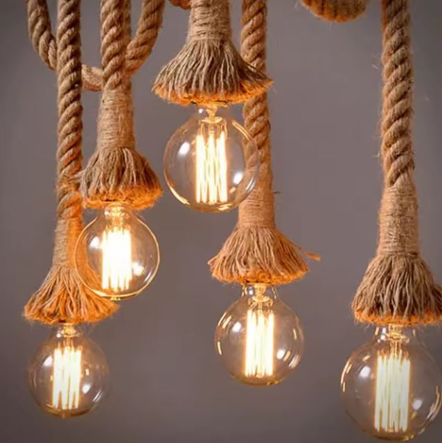 Gros plan sur une suspension corde et bois avec ampoules LED vintage, offrant un éclairage chaleureux et authentique.
