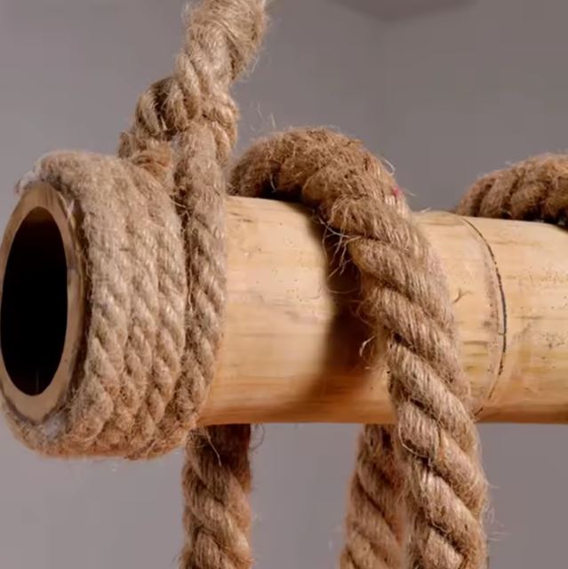 Gros plan sur une suspension corde et bois, mettant en avant la texture des matériaux naturels pour une décoration authentique.