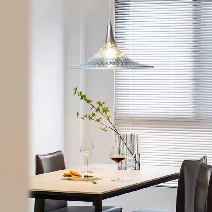 Au-dessus d’une table à manger, cette suspension corolle en acrylique apporte une touche design et contemporaine