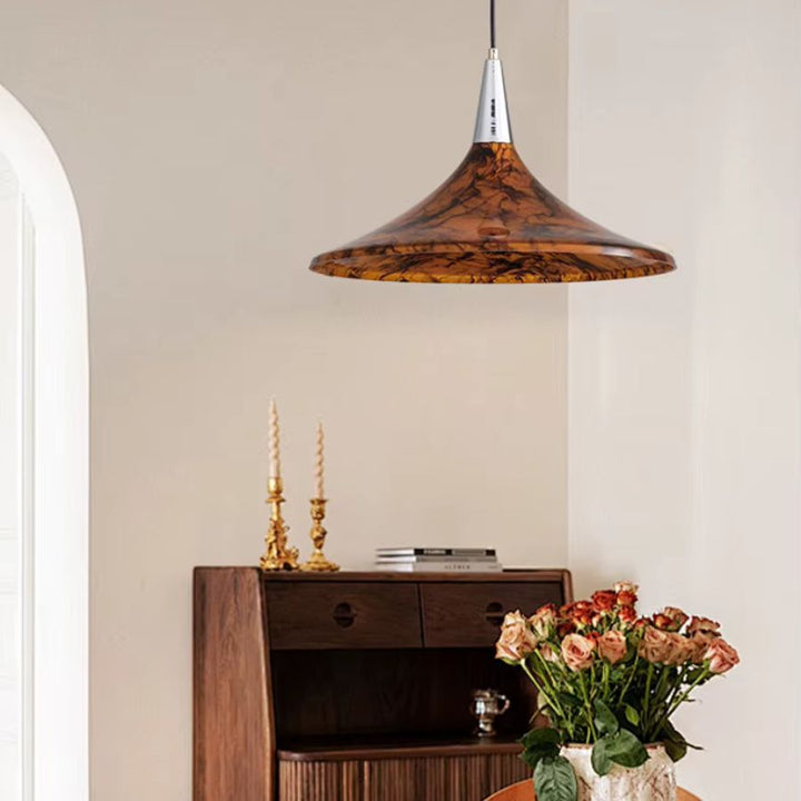 Dans un intérieur chaleureux, cette suspension corolle ambrée en acrylique mêle influences vintage, organiques et design