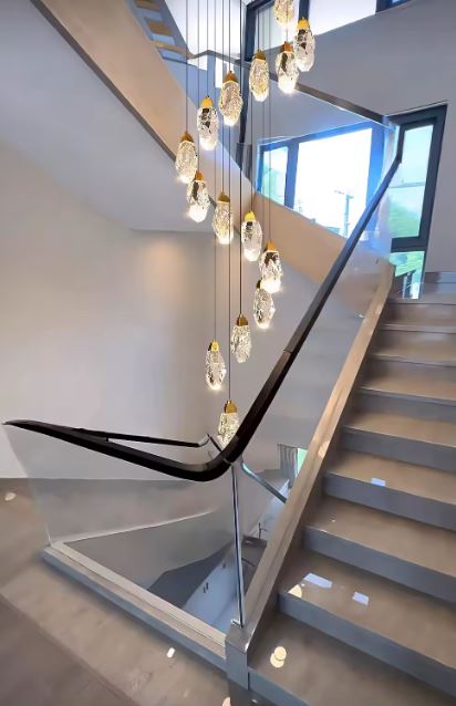 Suspension cristal en cascade pour cage d’escalier, luminaire luxueux à l’esthétique minérale et spectaculaire pour grand volume moderne.