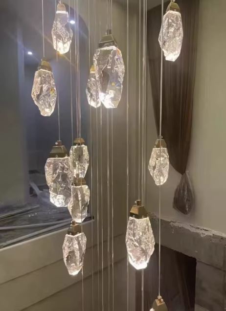 Suspension cristal en cascade au style glacier luxueux, luminaire raffiné aux formes minérales pour grand volume moderne.