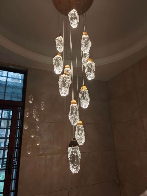 Suspension cristal design au style minéral, luminaire cascade prestigieux aux formes rocheuses et lumineuses raffinées.
