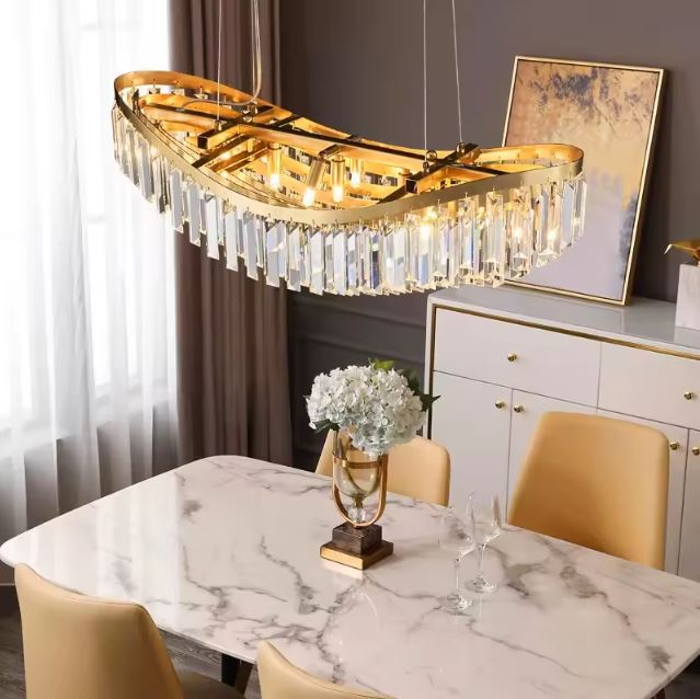 Suspension cristal dorée moderne au-dessus d'une table en marbre élégante.