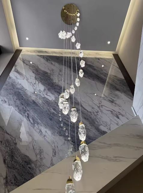 Suspension cristal XXL en cascade pour escalier monumental, luminaire de prestige aux formes minérales étincelantes.